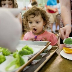 Naomi Sulpizio, 3, reacts as she sees a tray full of fresh broccoli on Monday at West Central Episcopal Mission./Tyler Tjomsland photo