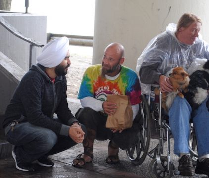Prabh Kochar, left, talks with a homeless family at a mobile langar - Tracy Simmons/SpokaneFAVS